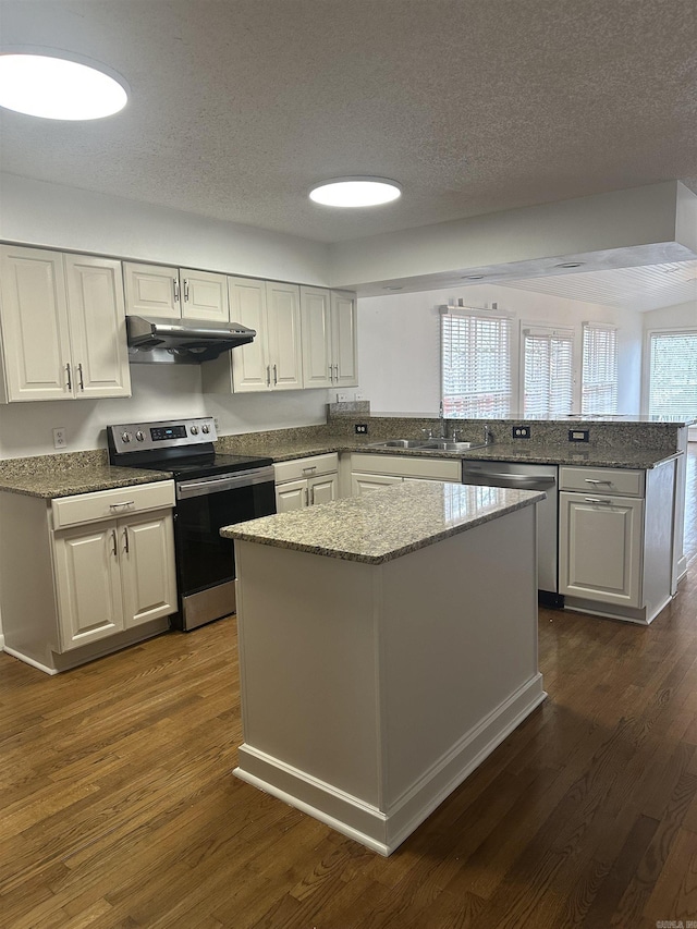 125 Pebble Beach Dr, Little Rock, AR 72212 - kitchen with appliances with stainless steel finishes, under cabinet range hood, a sink, a peninsula, and dark wood finished floors
