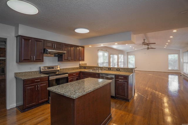 kitchen with kitchen peninsula, dark hardwood / wood-style flooring, stainless steel appliances, and vaulted ceiling