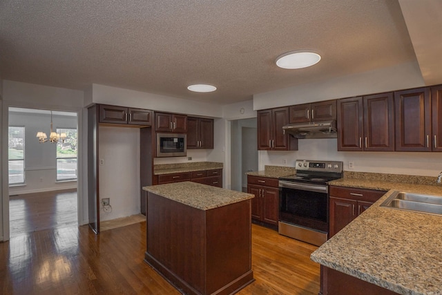 kitchen with hardwood / wood-style flooring, sink, stainless steel appliances, and hanging light fixtures