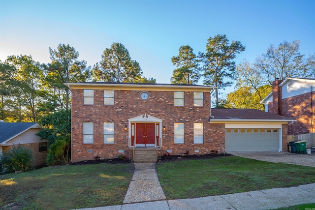 colonial home featuring a front yard and a garage