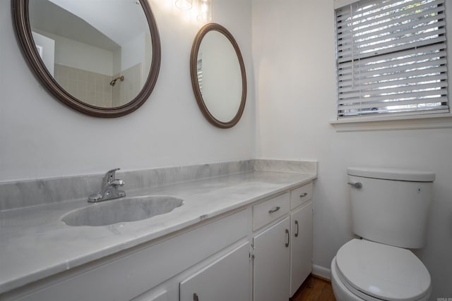 bathroom with hardwood / wood-style floors, vanity, and toilet