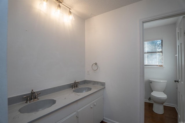 bathroom featuring hardwood / wood-style floors, vanity, a textured ceiling, and toilet