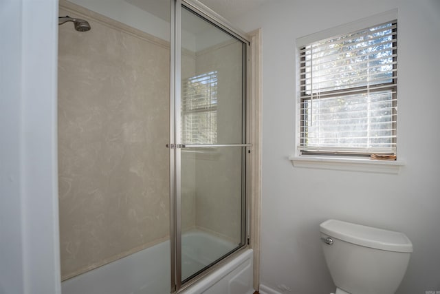 bathroom featuring plenty of natural light, toilet, and enclosed tub / shower combo