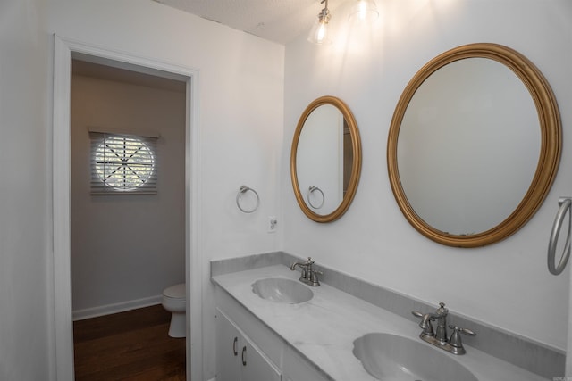 bathroom featuring hardwood / wood-style floors, vanity, a textured ceiling, and toilet