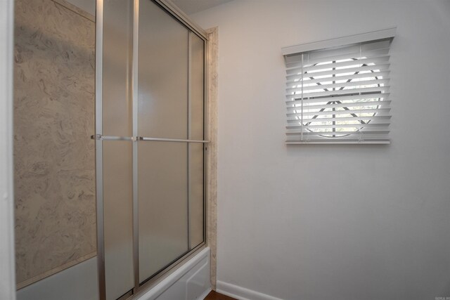 bathroom featuring shower / bath combination with glass door