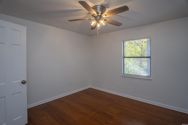 empty room with ceiling fan and dark wood-type flooring