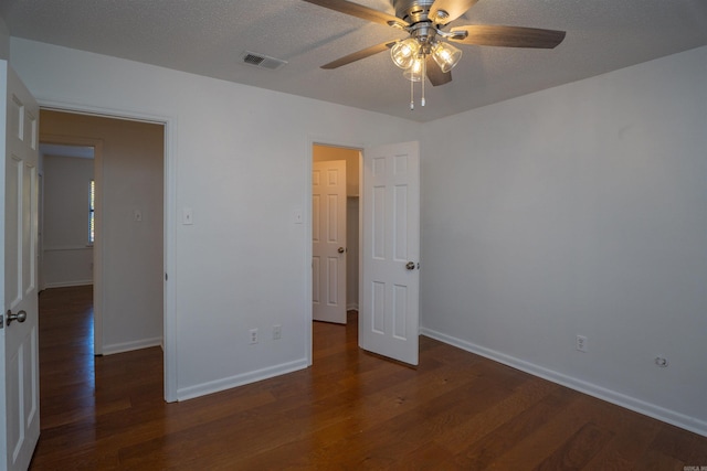 unfurnished bedroom with a textured ceiling, ceiling fan, and dark wood-type flooring