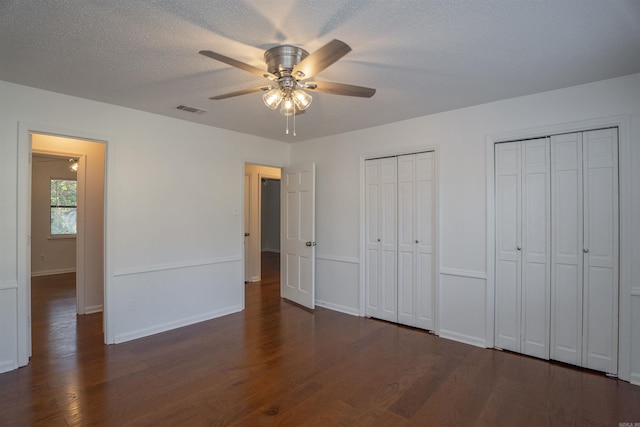 125 Pebble Beach Dr, Little Rock, AR 72212 - unfurnished bedroom with multiple closets, dark wood finished floors, baseboards, and ceiling fan