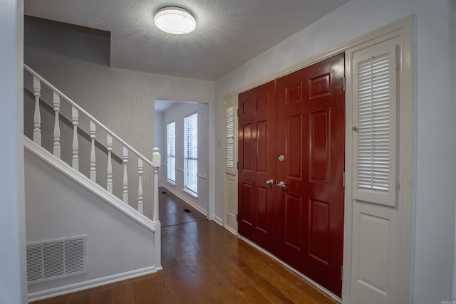 foyer with hardwood / wood-style floors and a textured ceiling