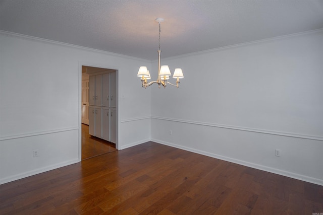 empty room featuring ornamental molding, an inviting chandelier, and dark wood-type flooring