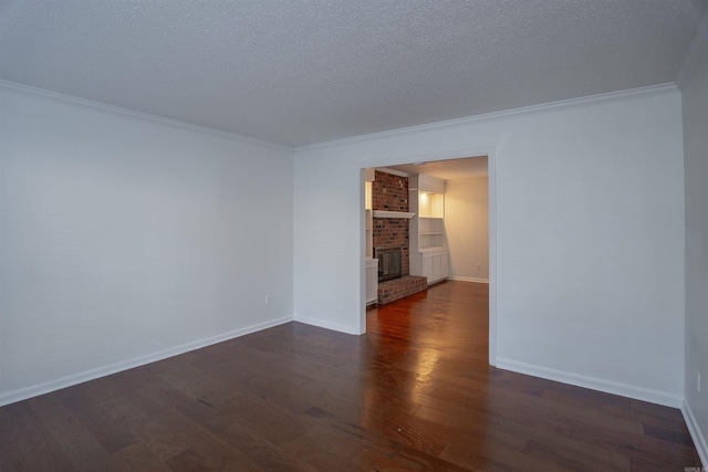 empty room featuring a fireplace, dark hardwood / wood-style flooring, ornamental molding, and a textured ceiling