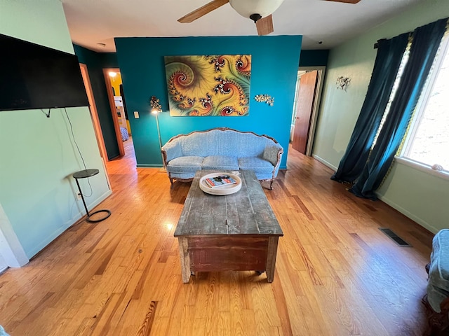 living room with ceiling fan and light hardwood / wood-style flooring