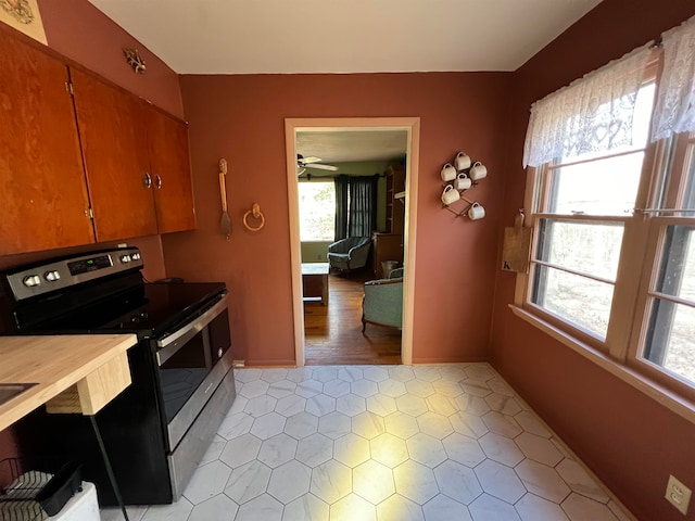 kitchen featuring light hardwood / wood-style flooring, ceiling fan, and electric stove