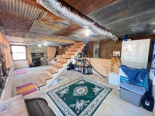 interior space with a stone fireplace, stacked washer / dryer, and electric panel