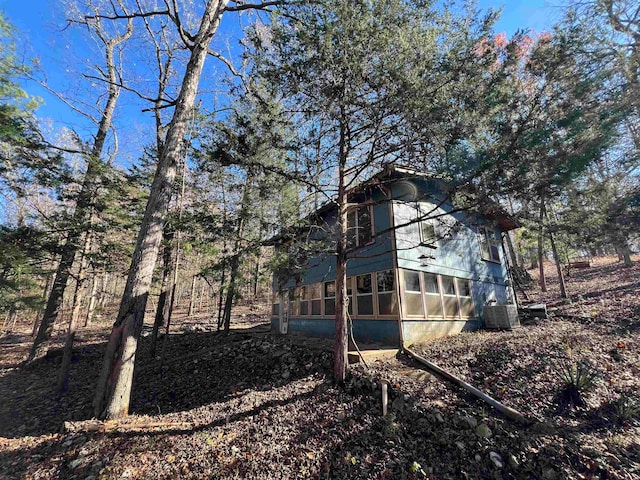 view of yard with central AC and a sunroom