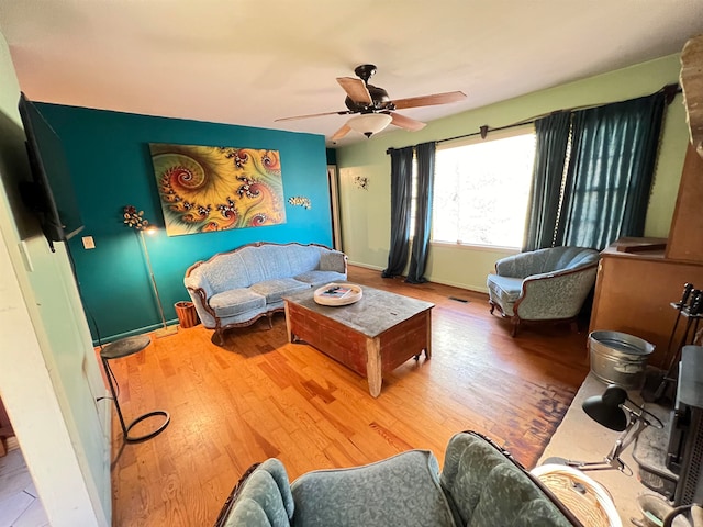 living room featuring wood-type flooring and ceiling fan