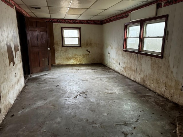 misc room featuring concrete floors and a drop ceiling