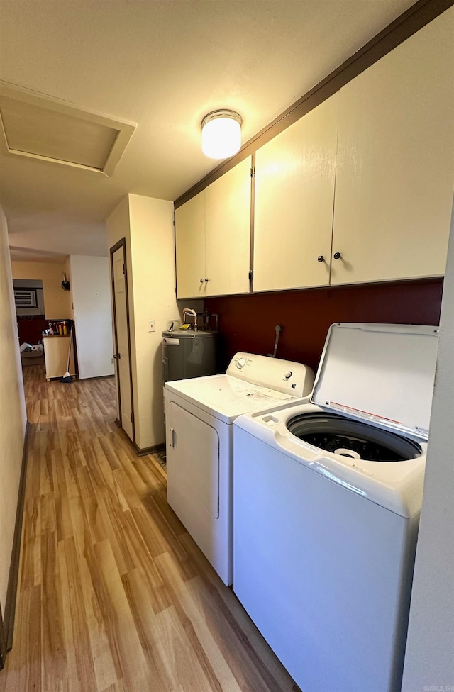 1107 Glenaire St, Mena, AR 71953 - washroom with washing machine and clothes dryer, cabinet space, light wood-style floors, water heater, and attic access
