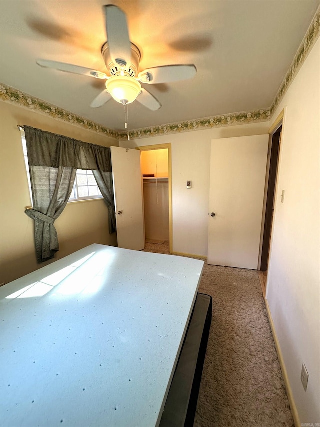 unfurnished bedroom featuring carpet, ceiling fan, and a closet