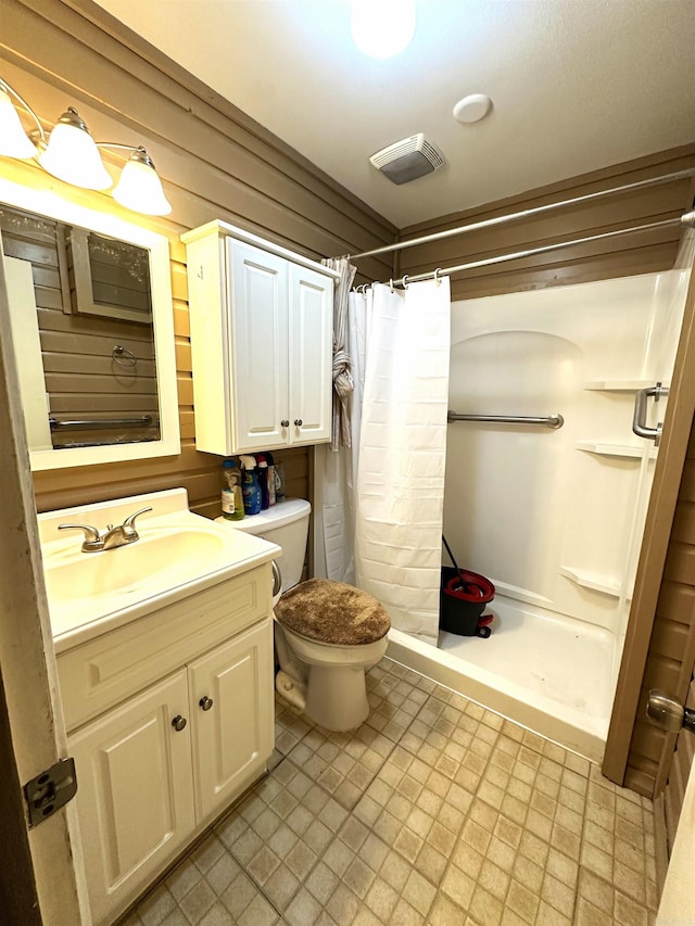 bathroom featuring toilet, vanity, and a shower with shower curtain