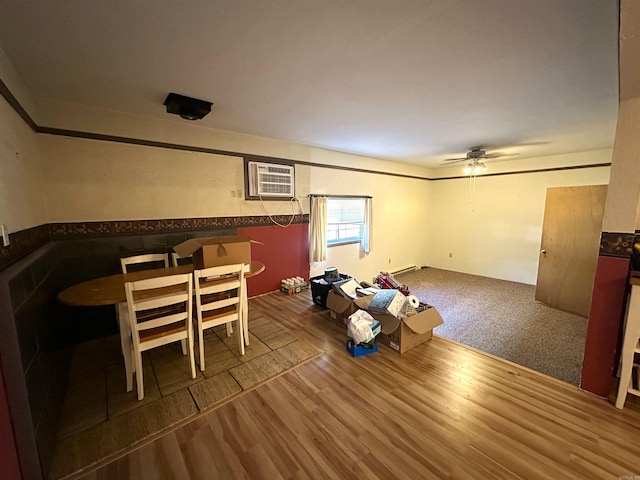 dining space with ceiling fan, hardwood / wood-style floors, and a wall mounted air conditioner