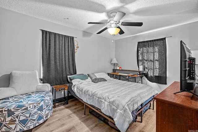 bedroom featuring a textured ceiling, light hardwood / wood-style flooring, and ceiling fan