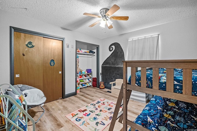 bedroom featuring hardwood / wood-style floors, a textured ceiling, a closet, and ceiling fan