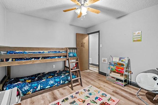 bedroom featuring ceiling fan, a textured ceiling, and hardwood / wood-style flooring