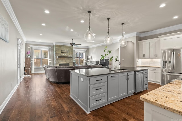 kitchen featuring dark hardwood / wood-style flooring, sink, stainless steel appliances, and hanging light fixtures