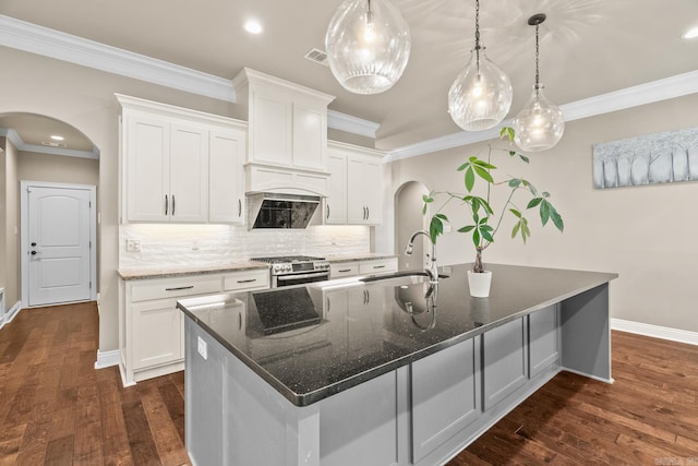 kitchen featuring white cabinets, dark hardwood / wood-style floors, a kitchen island with sink, and hanging light fixtures