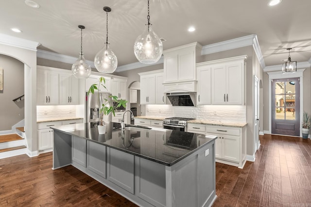 kitchen with white cabinetry, dark hardwood / wood-style flooring, a large island, and appliances with stainless steel finishes