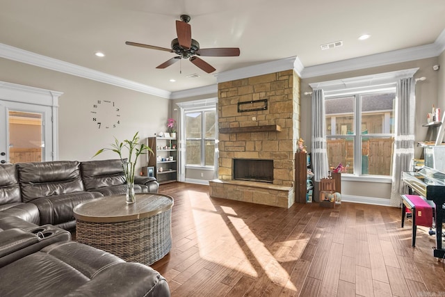 living room with ceiling fan, a fireplace, wood-type flooring, and ornamental molding