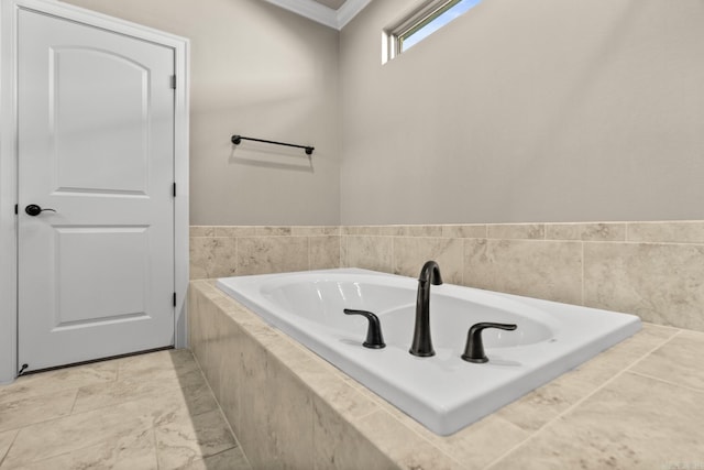 bathroom with ornamental molding and tiled bath