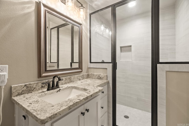 bathroom featuring vanity and a shower with door