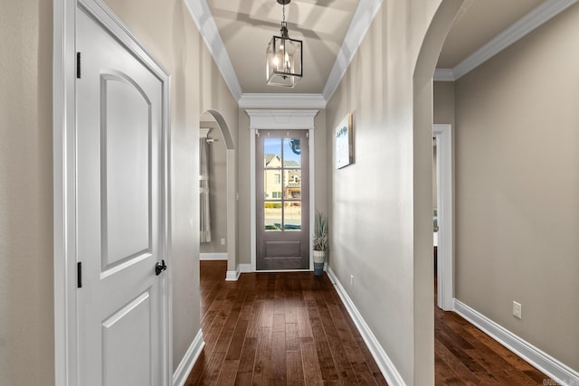 doorway with dark hardwood / wood-style floors, an inviting chandelier, and ornamental molding