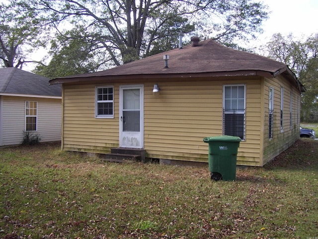 rear view of property with a yard