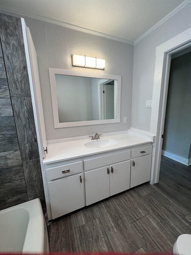 bathroom featuring a textured ceiling, vanity, hardwood / wood-style flooring, and crown molding