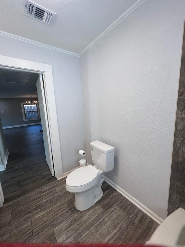 bathroom with crown molding, hardwood / wood-style floors, and toilet