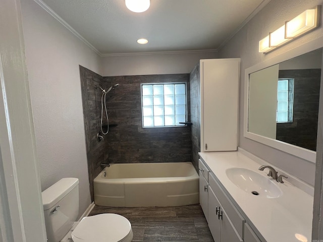 full bathroom featuring vanity, tiled shower / bath combo, toilet, and crown molding