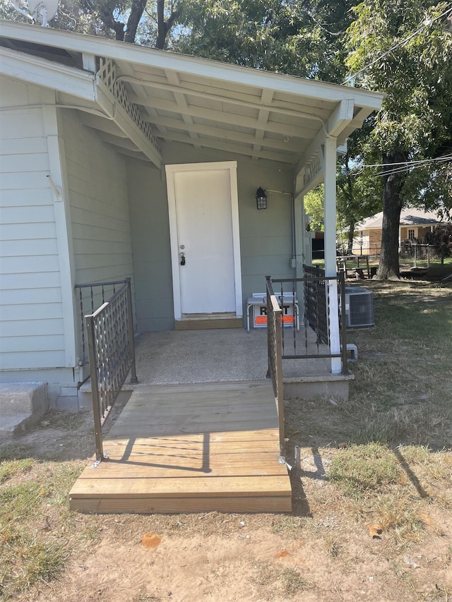 doorway to property featuring a porch and central AC