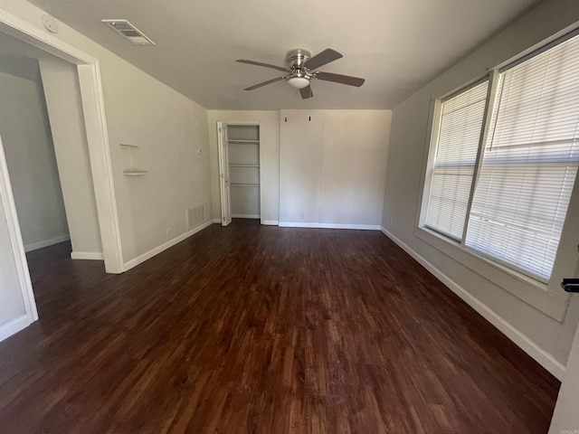 empty room featuring dark hardwood / wood-style floors, ceiling fan, and plenty of natural light