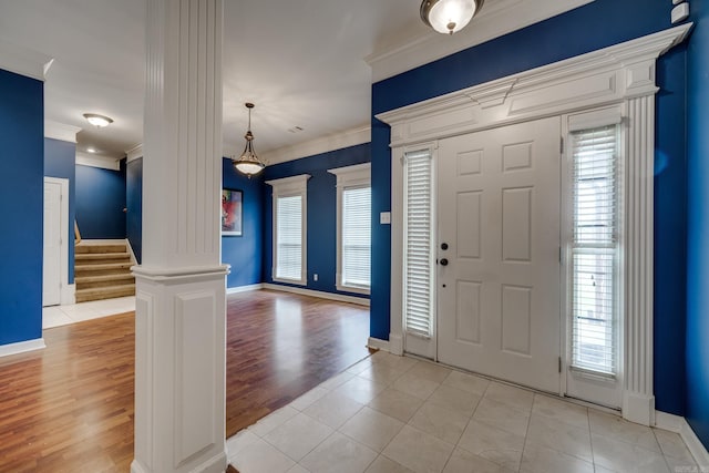 entrance foyer featuring ornate columns, crown molding, and light hardwood / wood-style floors