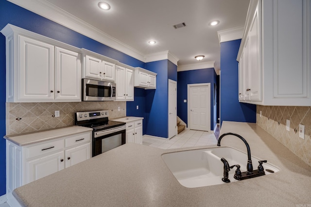 kitchen featuring white cabinetry, sink, stainless steel appliances, crown molding, and decorative backsplash