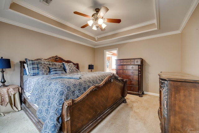 carpeted bedroom with a tray ceiling, ceiling fan, and ornamental molding