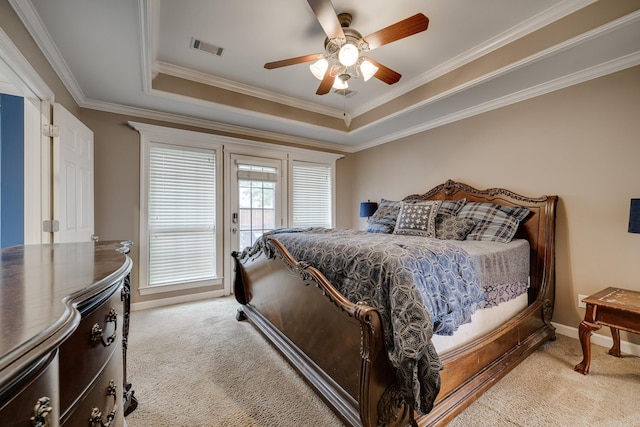 carpeted bedroom with a raised ceiling, ceiling fan, and ornamental molding