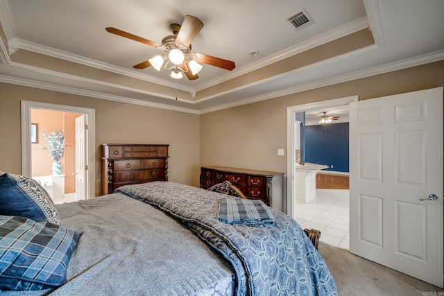 bedroom featuring ensuite bathroom, ceiling fan, and a raised ceiling