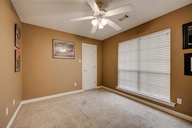 carpeted spare room with ceiling fan