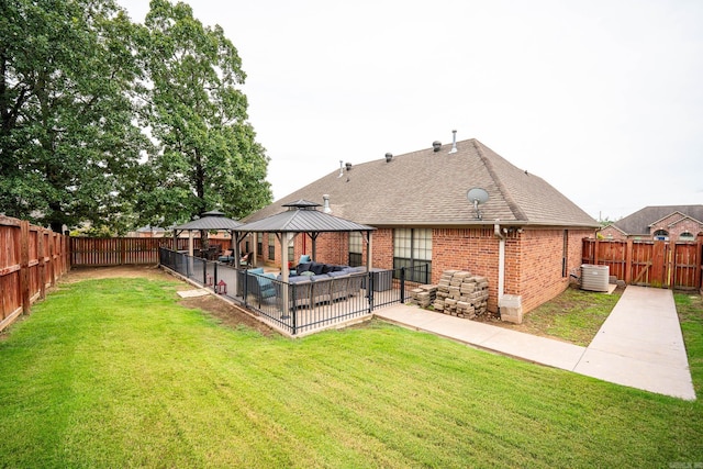 back of property featuring a gazebo, cooling unit, outdoor lounge area, and a lawn