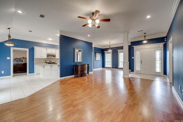 unfurnished living room with ceiling fan, light hardwood / wood-style floors, ornate columns, and crown molding