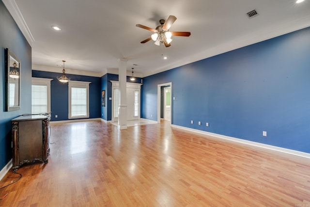 unfurnished living room with light wood-type flooring, ornate columns, ceiling fan, and crown molding